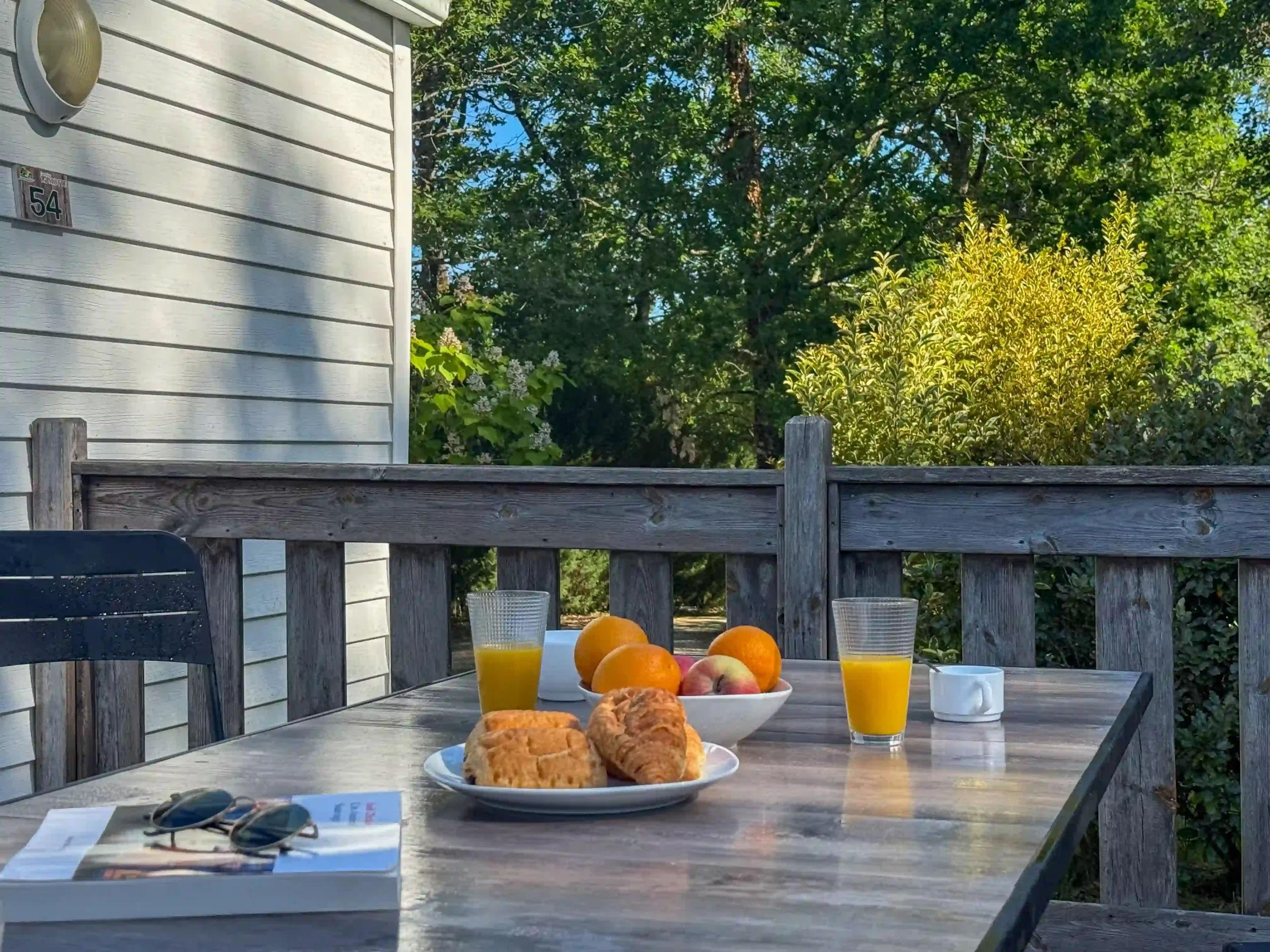 Petit déjeuner avec pain et viennoiseries sur la terrasse du mobil-home